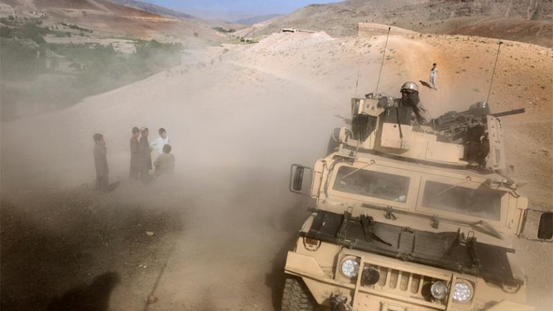 Niños afganos ven pasar un vehículo militar estadounidense en Afganistán. DIEGO IBARRA SÁNCHEZ / 5W